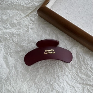 Close-up of matte burgundy hair claw clip with golden Barrette La France text detail
