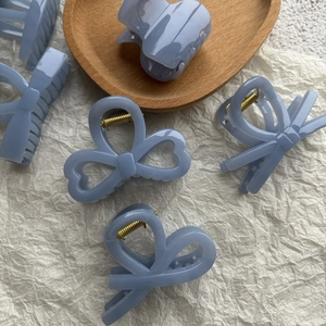 Détail de pinces à cheveux nceud bleu sel de mer et clips en résine sur plateau