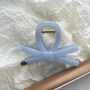 Detailed macro view of the light blue butterfly hair claw clip with golden metal spring
