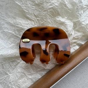 Détail de la pince à cheveux en motif écaille de tortue avec logo métallique doré Hand Made