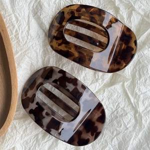 Chic tortoiseshell hair claw clips in caramel and grey on white textured paper