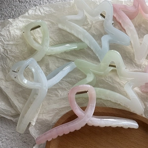 Détail de pinces à cheveux étoile de mer en acétate pastel avec finition nacrée élégante