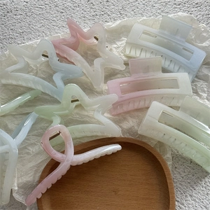 Détail de pinces à cheveux étoiles de mer pastel mat sur un plateau en bois rustique