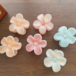 Gros plan de pinces à cheveux fleurs en gelée translucide avec perles sur fond bois
