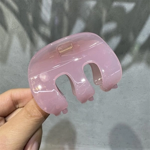 Macro detail of a large matte pink hair claw clip for elegant French style updos