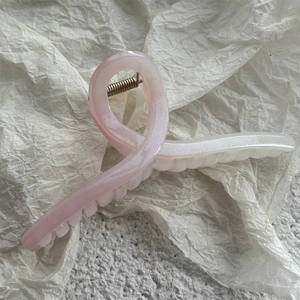 Détail de la pince à cheveux dégradé rose et blanc avec fini perlé et ressort métallique