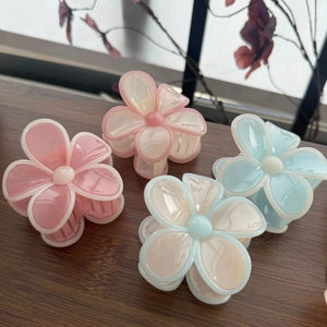 Détail de pinces à cheveux en forme de fleurs colorées sur une surface en bois