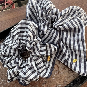Chouchou rayé bleu de style français avec étiquette dorée sur une surface en bois