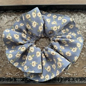 Détail du chouchou oversize en mousseline florale bleu-gris avec fleurs blanches