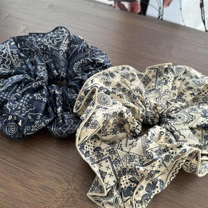 Vintage paisley print large scrunchie set in navy and cream on wooden surface