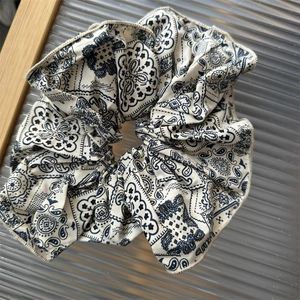 Blue paisley print fabric scrunchie with soft chiffon texture and pleated design