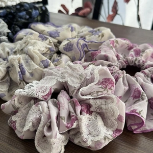 Elastici floreali con bordi in pizzo bianco rosa e viola su una superficie di legno