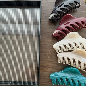 Macro view of 14cm large hair claws in black, burgundy, beige and cyan resin colors