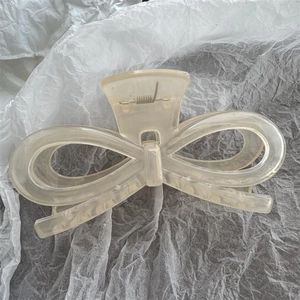 Detail einer großen mattierten Haarklammer in Schleifenform mit transparenter Optik