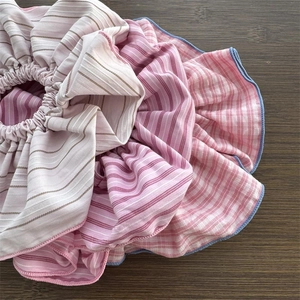 Handmade oversized pink striped scrunchie hair tie with blue piping on wooden background
