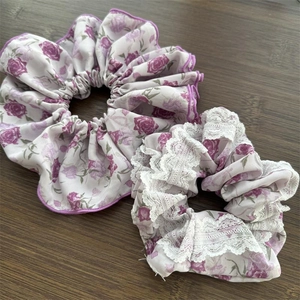 Dettaglio di elastici per capelli floreali con stampa a rose viola e ricamo in pizzo