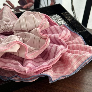 Close-up of pink striped scrunchie with layered ruffles and colorful stitching