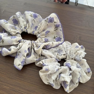 Dettaglio di set di elastici floreali con rose viola ed eleganti finiture in pizzo