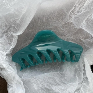 Macro shot of large 14cm dark green hair claw clip with glossy finish and smooth teeth
