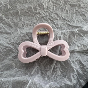 Dettaglio della pinza per capelli a fiocco rosa in acrilico con molla rinforzata