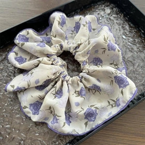 Dettaglio della stampa floreale con rose viola su elastico in chiffon con bordi cuciti
