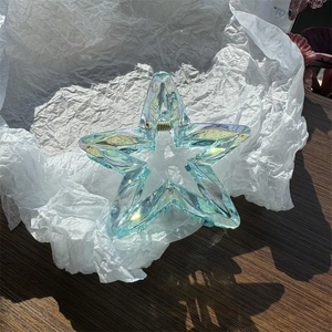 Détail macro de la pince à cheveux étoile aurora avec fini holographique et ressort