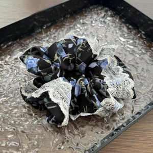Dettaglio di un elastico floreale con motivo blu e delicato bordo in pizzo bianco