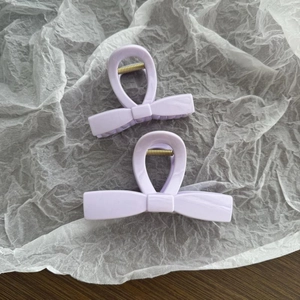 Λεπτομέρεια από ανοιχτό μοβ κλιπ μαλλιών πεταλούδα σε δύο μεγέθη σε λευκό χαρτί