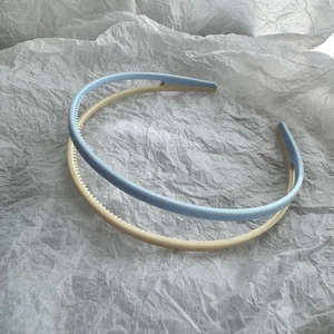 Close-up of candy-colored non-slip headbands with inner teeth on white paper