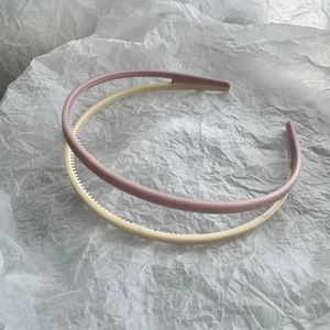 Detail of pink and beige slim headbands featuring non-slip inner teeth for secure grip