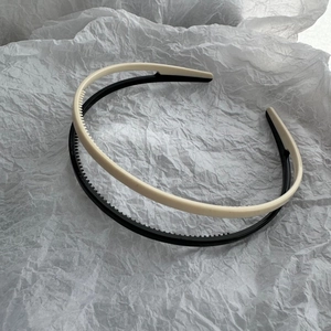 Detailed view of matte black and cream non-slip headbands with inner grip teeth texture