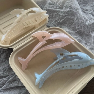 Three elegant dolphin-shaped hair claws in pearl white, pink, and light blue finishes