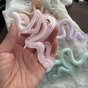 Detail view of wavy acrylic hair claws in multiple pastel colors and translucent texture
