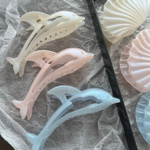 Detail of dolphin and shell hair claws in pearlescent acetate with fine glitter
