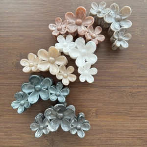 Floral pearlized hair claw clips in five Morandi colors on wooden background