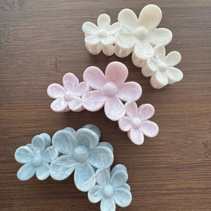 Three elegant flower hair claws with marble texture in white, pink and blue colors