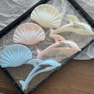 Detail of shell and dolphin hair clips with pearlescent finish in diverse colors