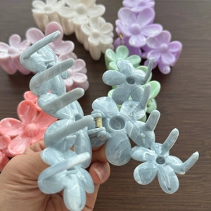 Floral acetate hair claw clip with marble texture and five small flowers in pastel colors