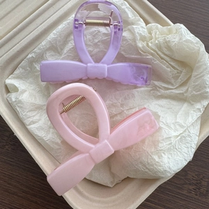 Detailed macro view of pastel bow hair clips with elegant marble pattern texture