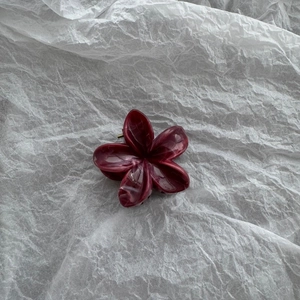 Detailed view of 4cm deep burgundy marble pattern flower hair claw clip on white background