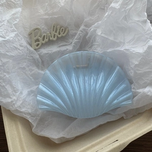 Detailed view of light blue shell hair claw clip with pearl luster and ribbed texture