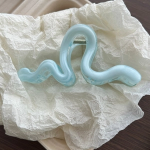 Detail of the ice blue wavy hair claw clip featuring marble texture and a silver spring