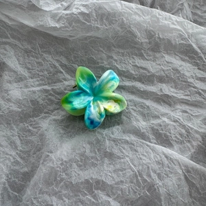 Detail view of a 4cm marble pattern flower hair claw clip with colorful floral acetic design
