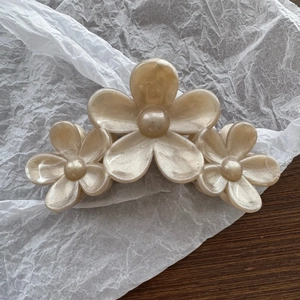 Detail showing the pearlescent finish and three flower shapes on a resin hair claw