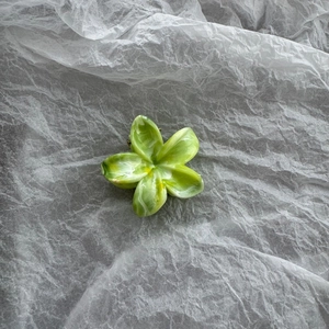 Detail of 4cm flower hair claw clip with green and white marble pattern texture