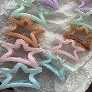 Molle per capelli a stella traslucide in colori pastello su carta bianca ruvida