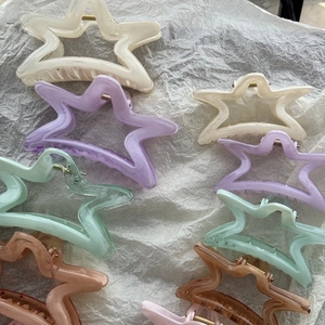 Dettaglio di fermagli per capelli a forma di stella in colori pastello e macaron