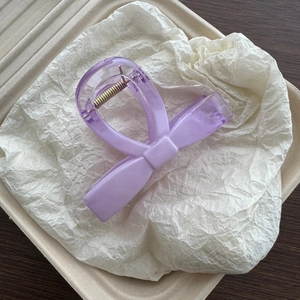 Elegant purple matte bow hair claw clip with strong metal spring on textured background