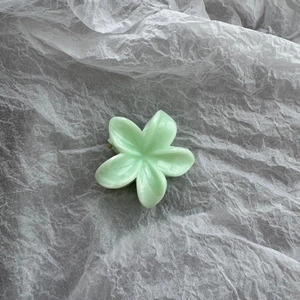 Detail of light green floral hair claw clip featuring a translucent resin finish