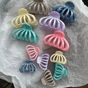 Detail view of multi-color marble texture hair claws in various sizes and elegant shades